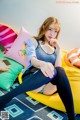 A woman sitting on top of a yellow bean bag chair.