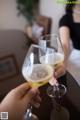 A couple of people toasting with wine glasses on a table.