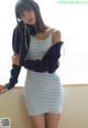 A woman in a blue and white striped dress posing for a picture.