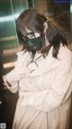 A woman wearing a face mask standing in an elevator.