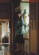 A woman standing in a kitchen next to a sink.