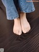 A person standing on a wooden floor with their bare feet.