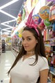 A woman in a white shirt is standing in a store.