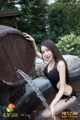 A woman in a black bathing suit sitting in a fountain.