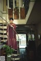 A woman in a long dress standing on a staircase.